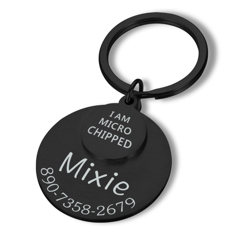 Black round engraved pet ID tag close up